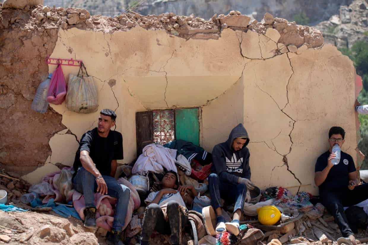 A family shelters near a damaged building in Targa, Morocco. Photo: Jalal Morchidi/EPA
